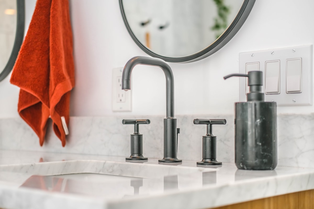 Malo Dental London countertop water flosser in white and chrome, shown on a marble bathroom shelf